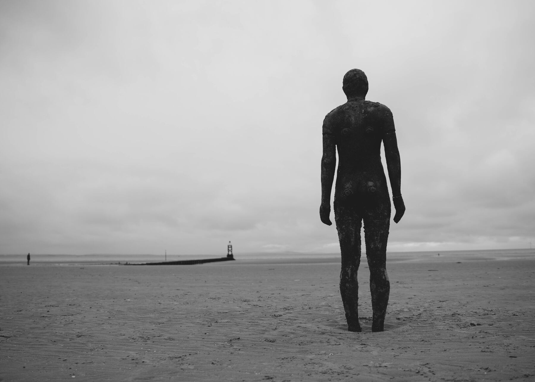 Figur am Strand, Rückenansicht